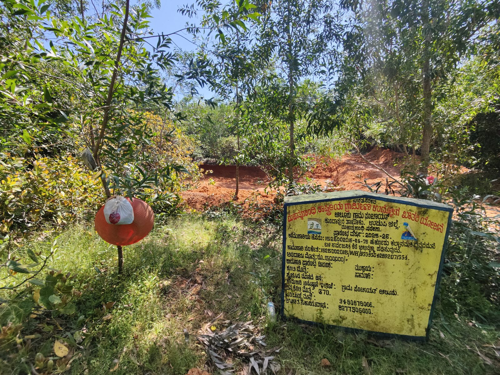 Public information board detailing the Development of the public pond near Harkuru Kalyanamaki Daivamane, in Aluru Panchayat under the MNREGA scheme. Almost all public infrastructure carry such painted information boards for public.